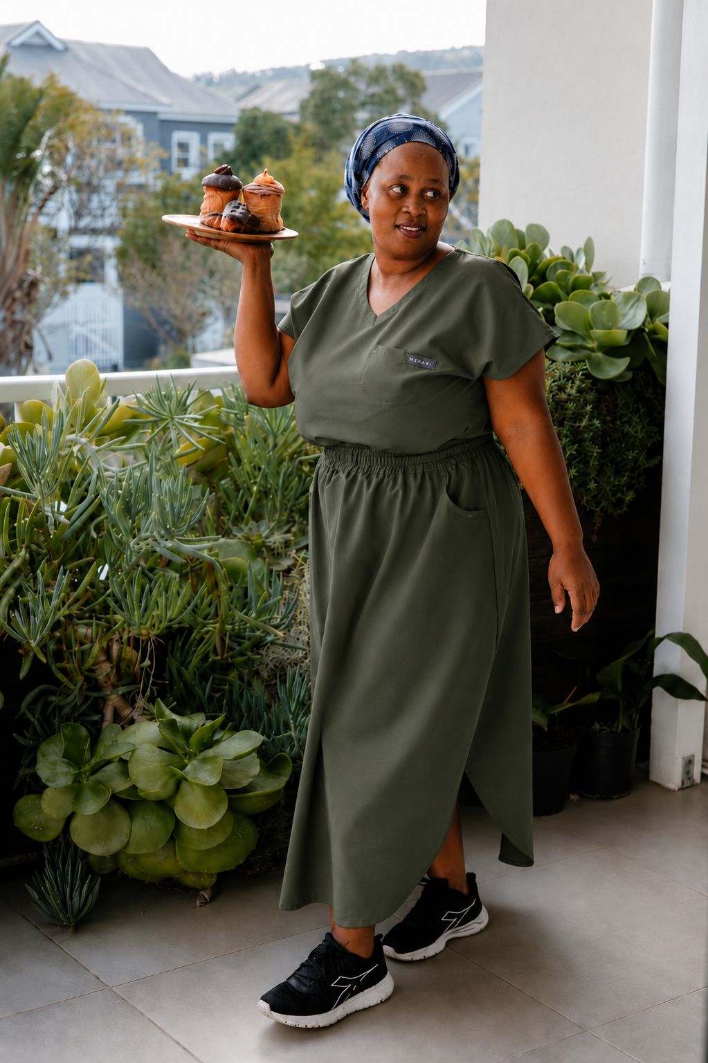 Cleaning lady wearing a green colour workwear skirt and a uniform top