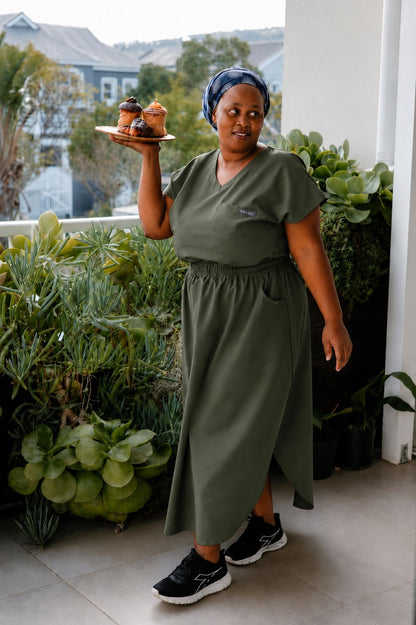 Cleaning lady wearing a green colour workwear skirt and a uniform top